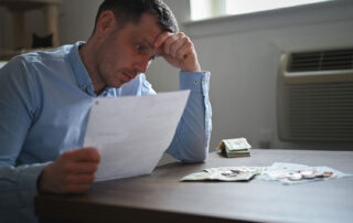 Experiencing financial stress, reviewing documents, table with money, restitution in Minnesota