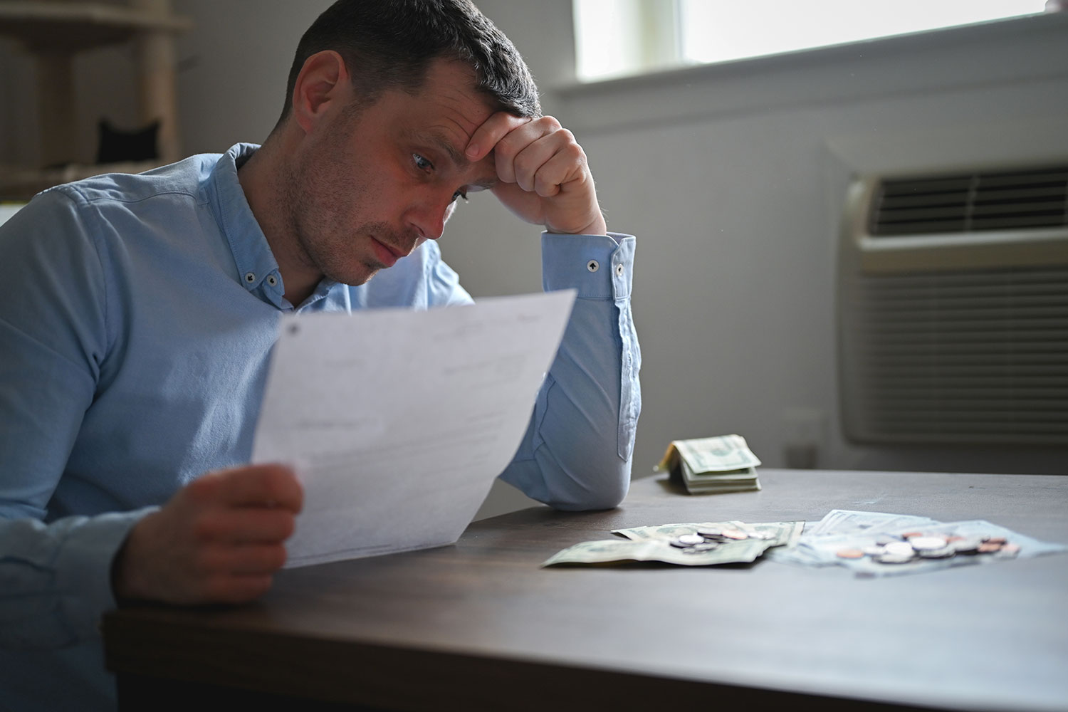 Experiencing financial stress, reviewing documents, table with money, restitution in Minnesota