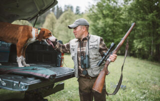 Man with hunting rifle and dog