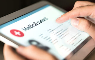 medical record open on tablet, digital file, held by individual reviewing documents