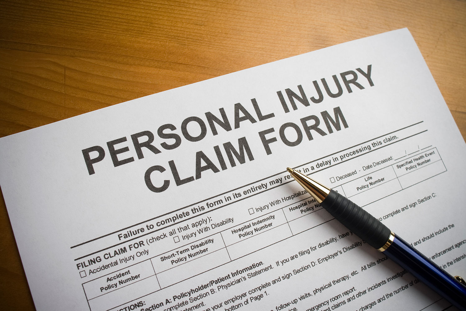 personal-injury-form-SCL-opt personal injury claim form with pen on wood grain surface